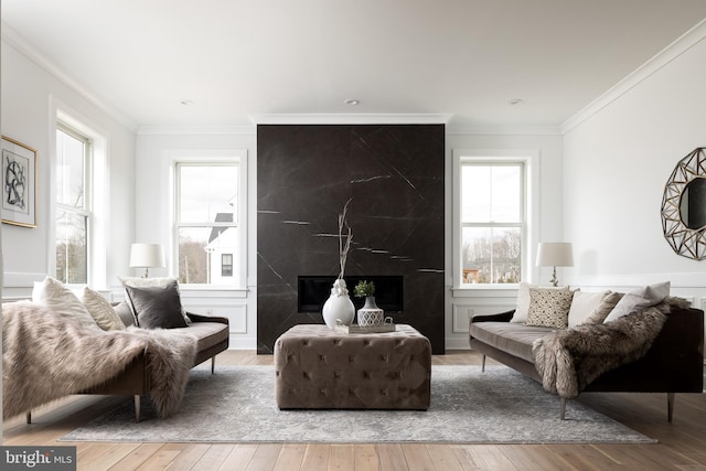 living area with hardwood / wood-style floors, a fireplace, and ornamental molding