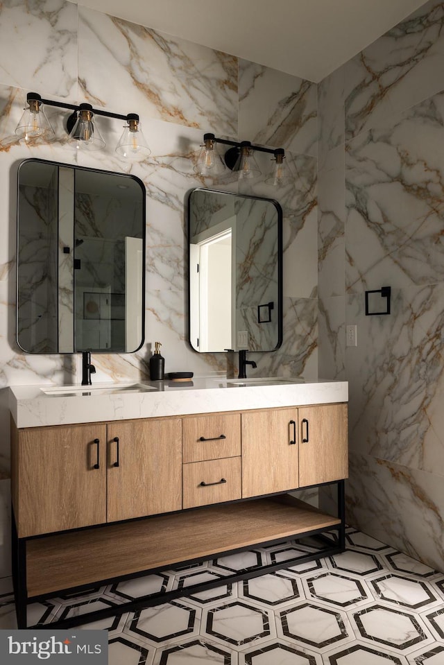 full bath featuring double vanity, stone wall, and a sink