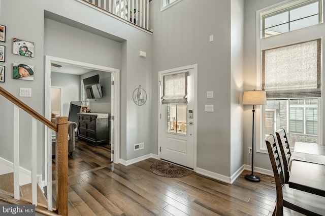 entryway featuring visible vents, baseboards, stairs, and hardwood / wood-style flooring