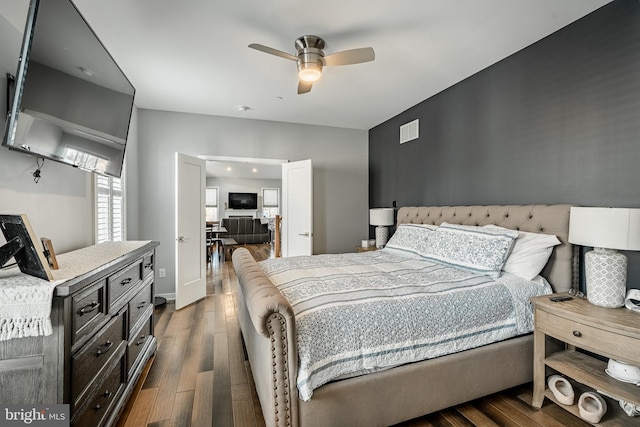 bedroom with visible vents, dark wood-style flooring, and ceiling fan