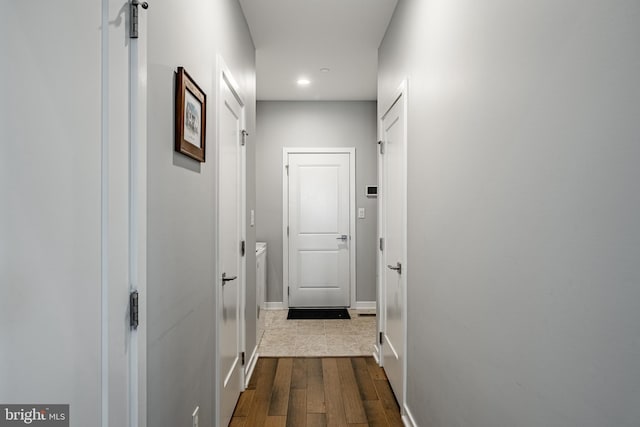 hallway featuring dark wood-style floors and baseboards