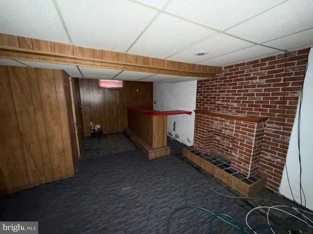 bar featuring a paneled ceiling, wood walls, and carpet floors