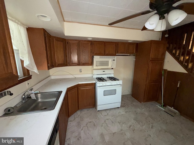 kitchen with white appliances, brown cabinetry, light countertops, and a sink