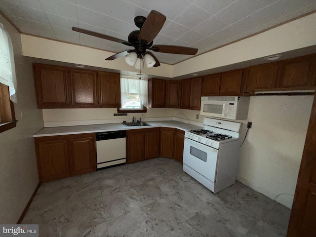 kitchen featuring white appliances, a ceiling fan, brown cabinetry, a sink, and light countertops