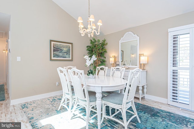 dining area featuring visible vents, baseboards, lofted ceiling, an inviting chandelier, and wood finished floors