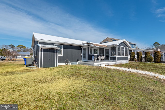 back of property with cooling unit, metal roof, a yard, and a sunroom