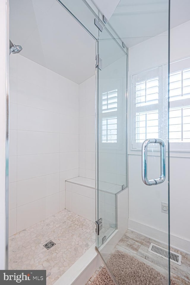 bathroom featuring baseboards, visible vents, and a stall shower