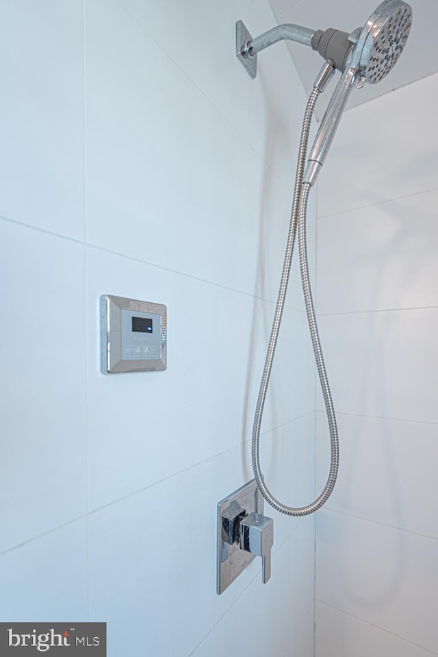 interior details featuring a tile shower