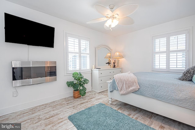 bedroom featuring wood finished floors, baseboards, and ceiling fan