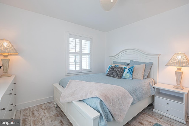 bedroom featuring wood finished floors and baseboards