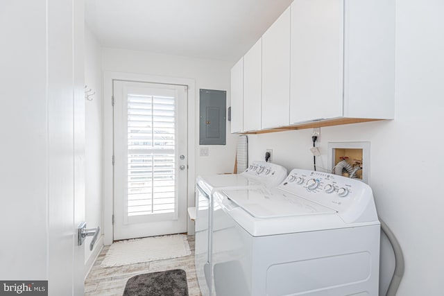 laundry area with electric panel, cabinet space, light wood-type flooring, and independent washer and dryer