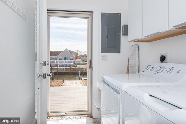 clothes washing area with electric panel, cabinet space, and independent washer and dryer