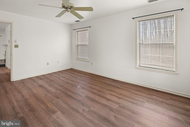 empty room featuring baseboards, ceiling fan, and wood finished floors