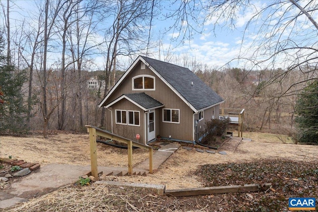 rustic home featuring roof with shingles