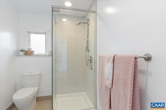 bathroom featuring a shower stall, toilet, and baseboards