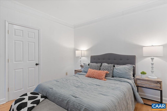 bedroom with crown molding and wood finished floors