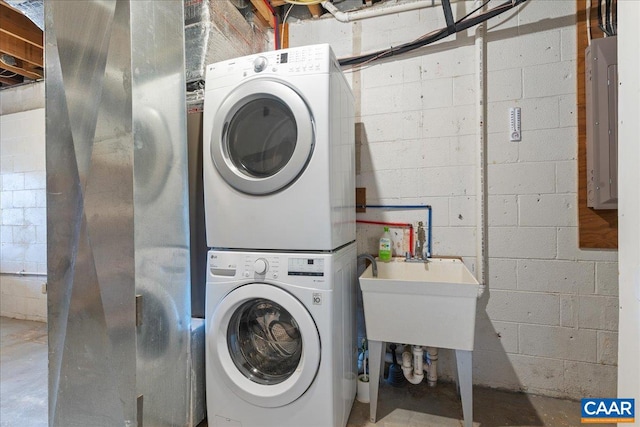 washroom featuring electric panel, laundry area, and stacked washing maching and dryer