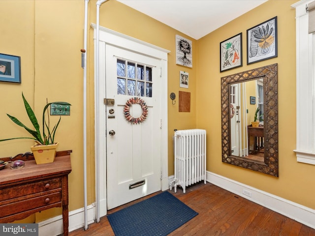 interior space featuring radiator heating unit, dark wood-style floors, and baseboards