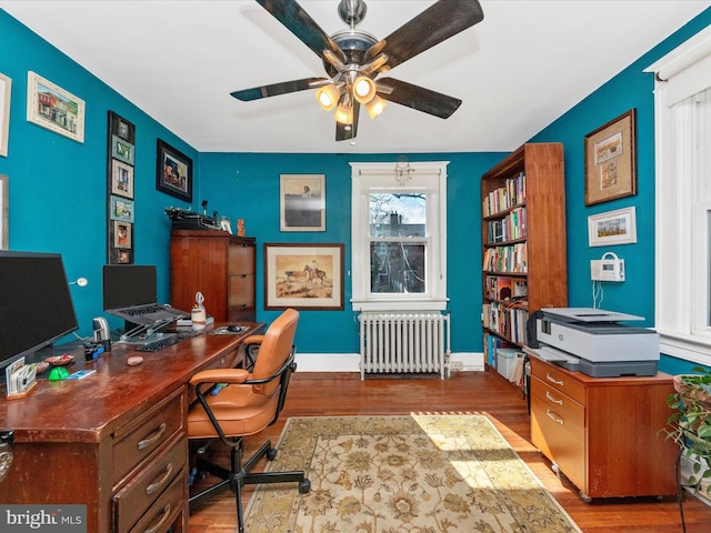 office featuring baseboards, a ceiling fan, wood finished floors, and radiator heating unit