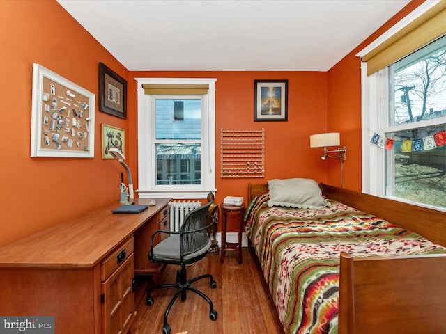 bedroom with radiator and wood finished floors