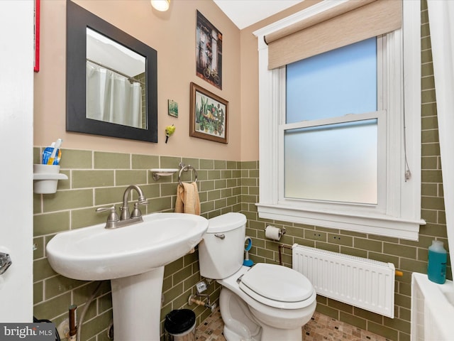 full bath featuring wainscoting, toilet, radiator, and tile walls