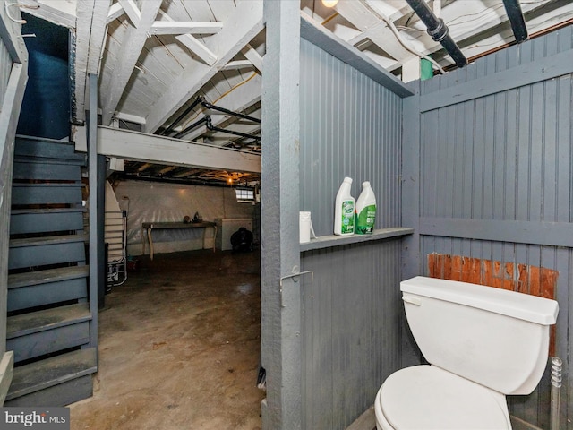 bathroom with toilet and unfinished concrete flooring