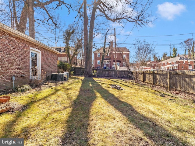 view of yard with central air condition unit and fence