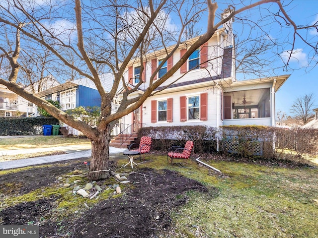 view of front of home with a chimney and a sunroom