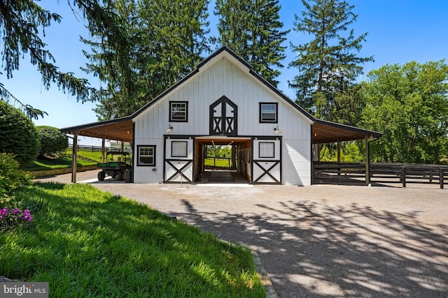 view of barn with a carport and an exterior structure