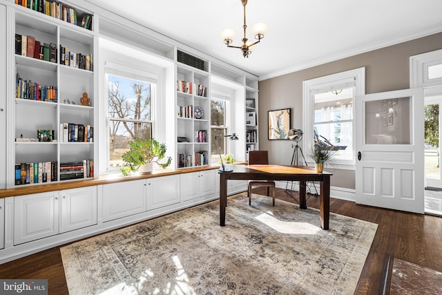 office space featuring dark wood finished floors, an inviting chandelier, built in shelves, and ornamental molding