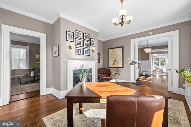 dining space featuring a premium fireplace, a notable chandelier, dark wood-style floors, and ornamental molding