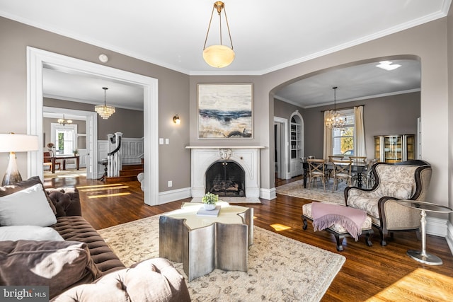 living area with a wealth of natural light, arched walkways, a notable chandelier, and a fireplace