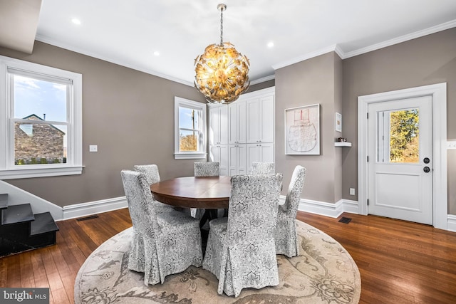 dining area featuring hardwood / wood-style floors, crown molding, a healthy amount of sunlight, and baseboards