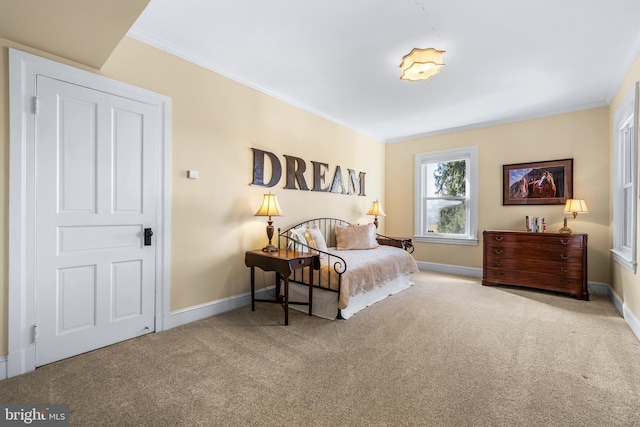 carpeted bedroom featuring crown molding and baseboards