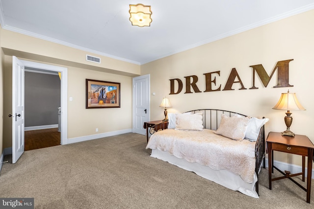 carpeted bedroom with visible vents, crown molding, and baseboards