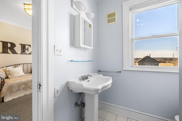 bathroom featuring visible vents, baseboards, and ornamental molding