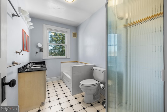 bathroom with tile patterned floors, a garden tub, toilet, and vanity