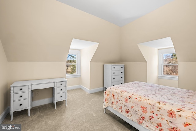 bedroom featuring baseboards, lofted ceiling, and light colored carpet