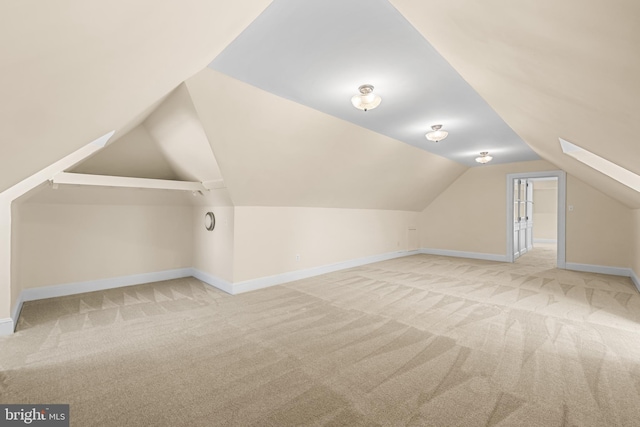 additional living space featuring carpet flooring, lofted ceiling, and baseboards