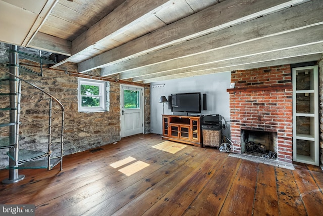 unfurnished living room featuring beam ceiling, a fireplace, visible vents, and wood-type flooring