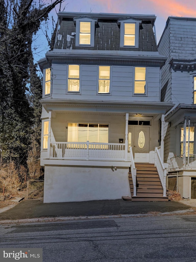 second empire-style home with a porch and mansard roof