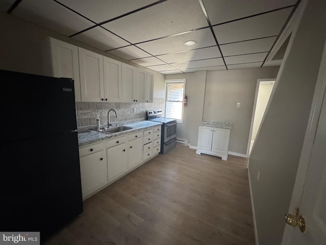 kitchen with white cabinets, freestanding refrigerator, electric stove, and a sink