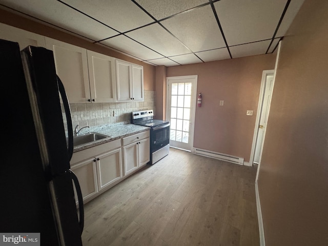 kitchen featuring light wood-type flooring, stainless steel range with electric stovetop, a sink, freestanding refrigerator, and a baseboard radiator