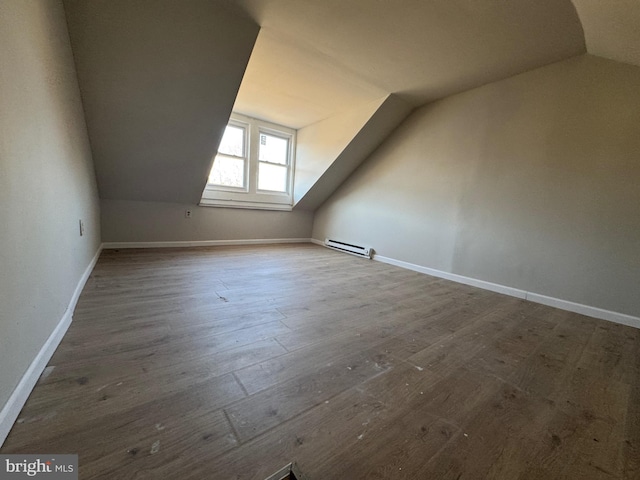 bonus room with a baseboard radiator, baseboards, dark wood-type flooring, and vaulted ceiling