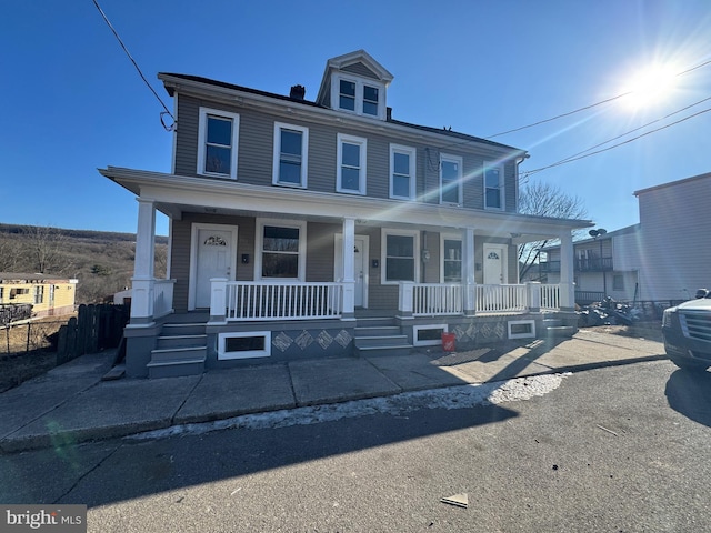 american foursquare style home with a porch and fence