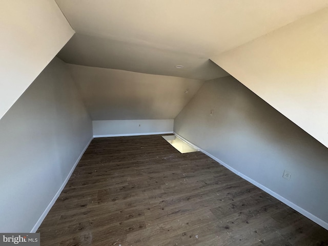 bonus room featuring dark wood-style floors, baseboards, and vaulted ceiling