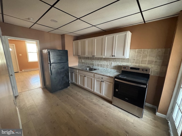 kitchen featuring a sink, a baseboard heating unit, freestanding refrigerator, light wood finished floors, and stainless steel electric range oven