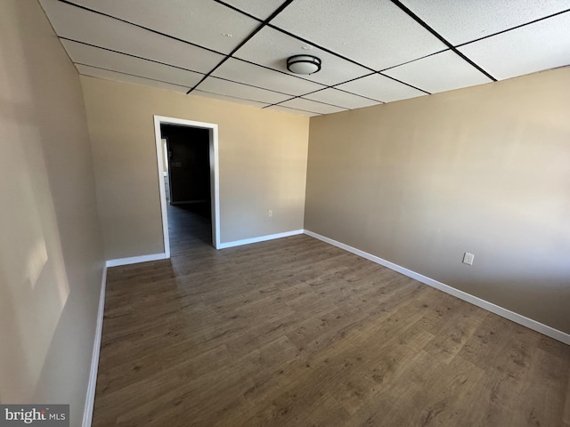 unfurnished room featuring a drop ceiling, baseboards, and wood finished floors