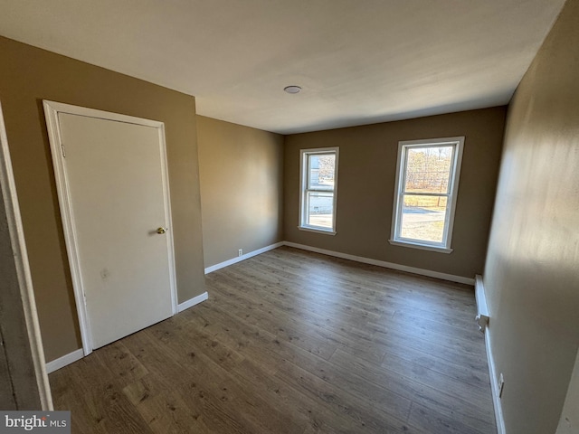 unfurnished bedroom featuring wood finished floors and baseboards