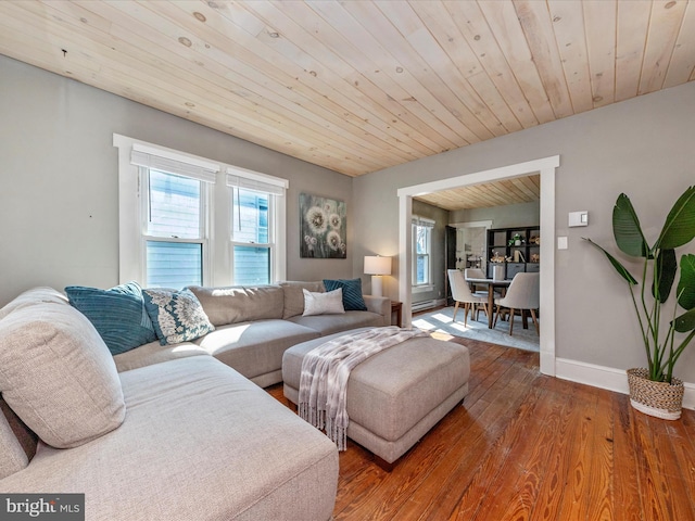 living area featuring wood ceiling, baseboards, and wood finished floors